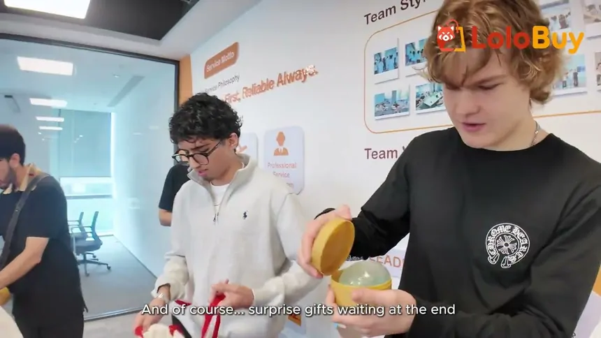 Still from Lolobuy's vlog: two creators in an office with Lolobuy branding on the wall